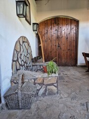 Wooden arched doors leading to the wine cellar. Lantern above the door. Large wicker basket. winery