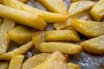 Homemade golden potato wedges baked in the oven, close-up