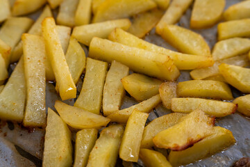 Homemade golden potato wedges baked in the oven, close-up