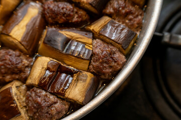 Homestyle eggplant and meatball stew cooked in a metal pot
