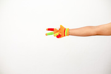 Colorful Knitted Glove on Hand Making Peace Sign Against White Background