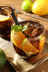 Refreshing Cuba libre cocktail with mint on wooden table, closeup