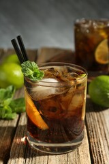 Refreshing Cuba libre cocktail with mint on wooden table