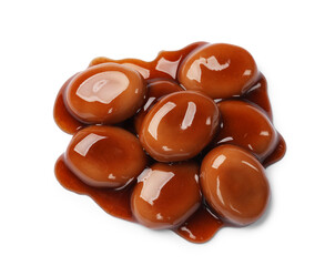 Tasty sweet candies and caramel sauce isolated on white, top view