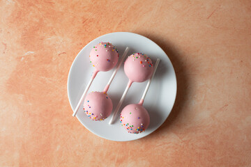 A top down view of some cake pops, on a plate..