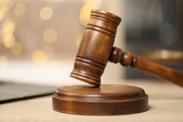 Judge's gavel on wooden table in office, closeup. Bokeh effect