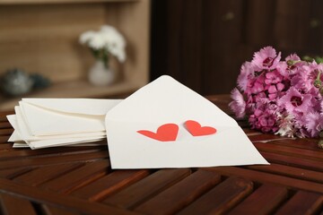 Love letters, red hearts and flowers on wooden table indoors, closeup