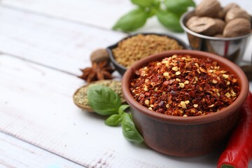 Different aromatic spices on white wooden table, closeup. Space for text