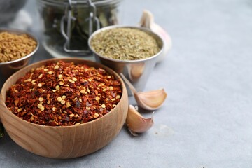 Different aromatic spices on grey table, closeup. Space for text