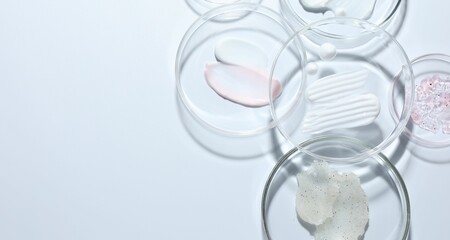 Different cosmetic products in Petri dishes on white background, flat lay. Space for text