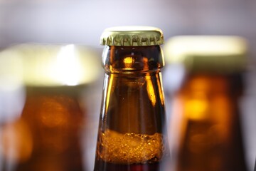 Bottle of tasty beer on blurred grey background, macro view