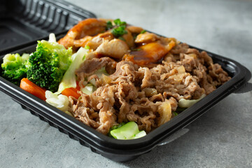 A view of a container of beef gyudon and chicken teriyaki.
