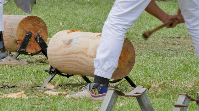 Shaving down wood logs with axe
