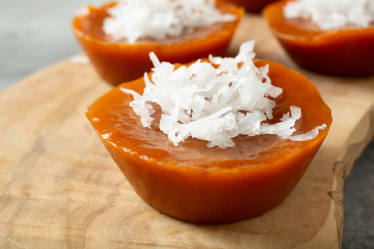 A closeup view of kutsinta, on a wood board.