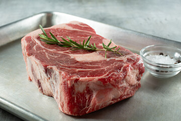 A closeup view of a choice ribeye steak on a baking sheet.