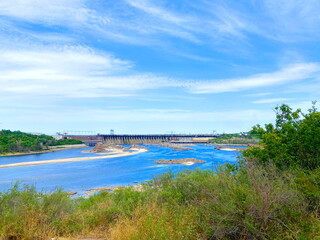 View from the thickets of Khortytsia island on the Dnieper dam under a blue spring sky shaded by a cloud cover.