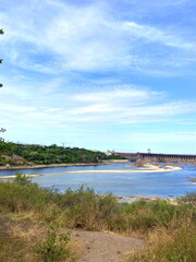 View from the thickets of Khortytsia island on the Dnieper dam under a blue spring sky shaded by a cloud cover.
