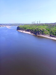 View from the Arch Bridge on the calm water surface of the Dnieper that washes the sandy shores and rocky cliffs of Khortytsia Island.
