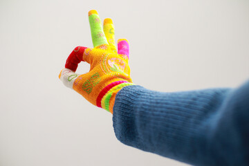 Colorful Hand Gesture: A Vibrant Display of Approval with Unique Artistic Gloves