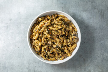 A top down view of a bowl of pesto chicken cauliflower pasta.
