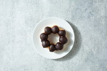 A top down view of a chocolate mochi donut, on a plate.