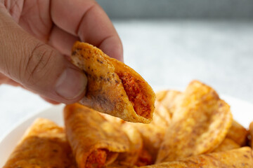A closeup view of a hand holding a mini taco.