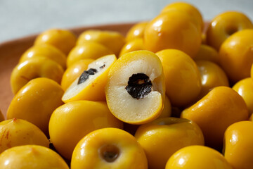 A closeup view of a pile of nance, featuring one that is cut in half.