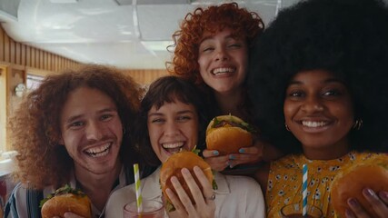 Friends gather in a nostalgic diner, relishing delicious burgers and refreshing sodas around a cozy booth, capturing a moment of joy and connection