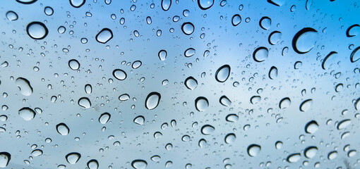 Abstract rain drops: A close-up view of pristine raindrops on a window or glass surface, creating a...