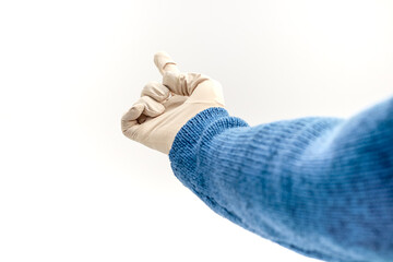 Person wearing a blue sweater and latex glove pointing up on a white background