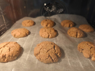 Freshly baked oat cookies cooling in oven