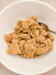 Close up of brown powdery halva substance in white bowl