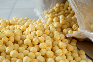 A view of a popular crispy corn puff cereal spilling out of the package.