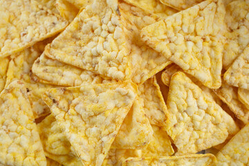 A top down view of a pile of popped corn chips, as a background.