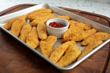 A view of a baking sheet of gluten-free chicken tenders.