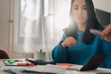 Woman managing home finances and calculating bills at home office