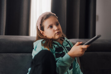 Bored girl watching television changing channels on sofa
