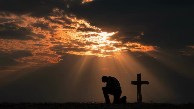 A person kneeling on the ground in front of a cross with sun rays streaming through the clouds illuminating their face as they close their eyes in a heartfelt gesture of forgiveness