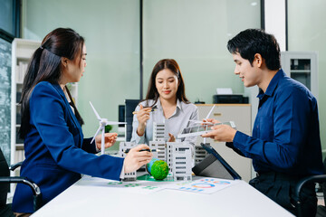 Business Team Meeting with Wind Turbine, Earth Model, and Building Prototype for Clean Energy