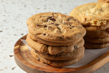 A view of a tray of cookies, featuring a stack of chocolate chip cookies.