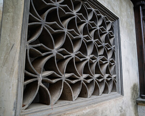 Black and white photo of a vintage concrete ventilation block wall with repetitive square openings, creating a strong geometric pattern and retro architectural texture.
