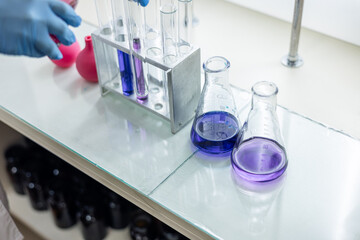 Laboratory analysis. Flask and test tubes on white table indoors, closeup. Laboratory test-tubes...