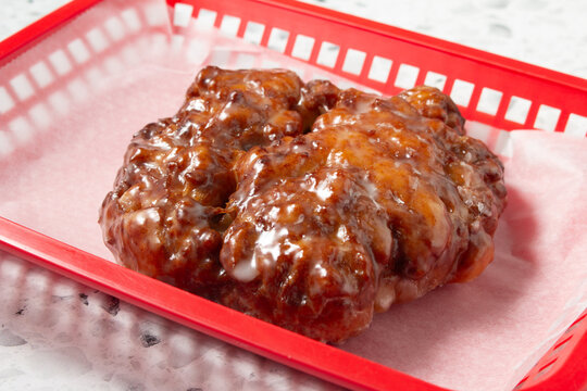 A view of an apple fritter, in a basket.