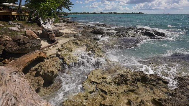 Establishing shot of ocean beach with rocks and pebbles in slow motion at summer day in Vancouver, Canada, North America. Day time on September 2021. Still camera. ProRes 422 HQ.