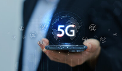 Hand holding smartphone with 5G icon and global network interface, representing high-speed wireless technology, digital connectivity, IoT, and future communication concept. communication network.