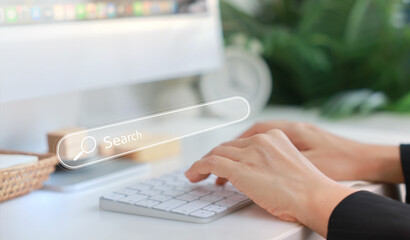 Hands typing on a white keyboard with search bar overlay, representing internet browsing, SEO, online research, digital marketing, communication, data input, coding and information search concept.