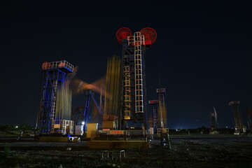 Oil rig at the background of refinery by night. Oil and gas industry.