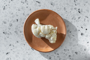 A top down view of a piece of lion's mane mushroom, on a plate.