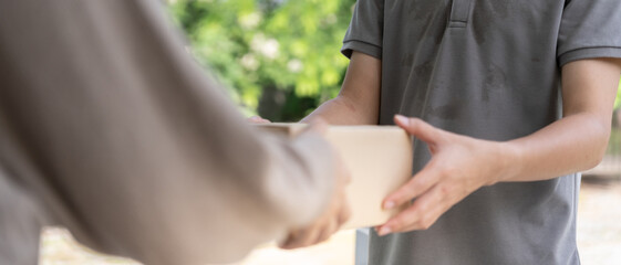 woman receives boxes parcel from courier in front house. Delivery man send deliver express. online...