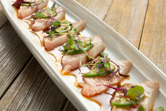 A closeup view of a plate of yellowtail carpaccio.